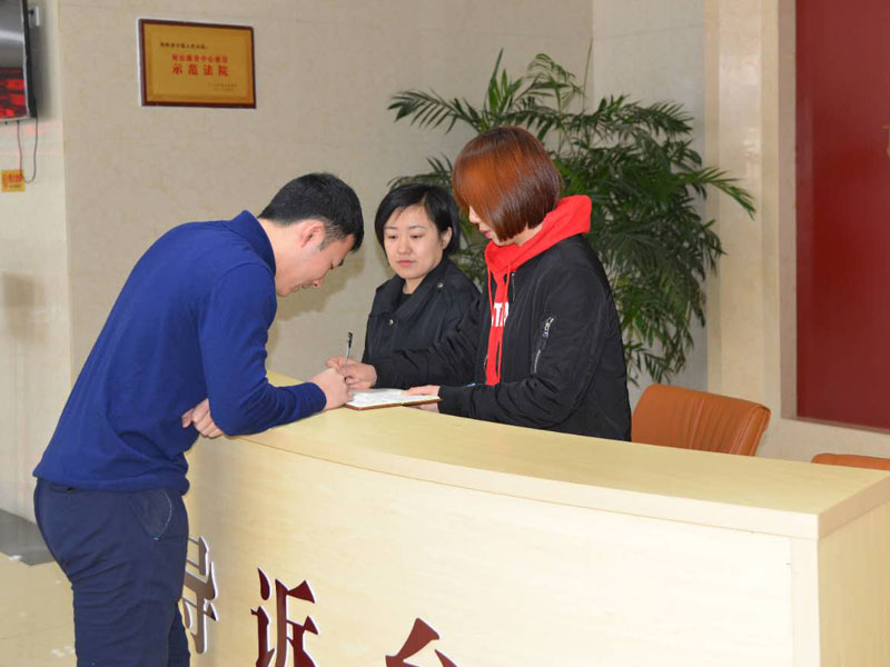 圖二，記者和導(dǎo)訴臺(tái)工作人員一起指引市民查詢(xún)信息
