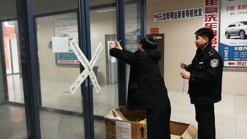 法官帶領(lǐng)法警正在給所騰房屋貼封條