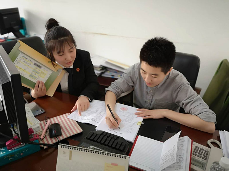 書記員趙春陽(yáng)指導(dǎo)記者填寫開庭傳票