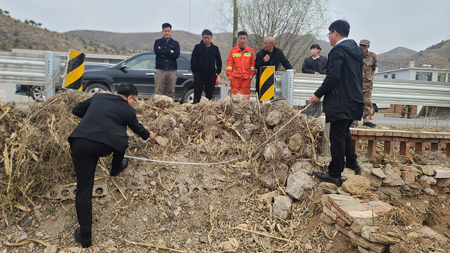 執(zhí)行干警現(xiàn)場丈量石墻占道面積。
