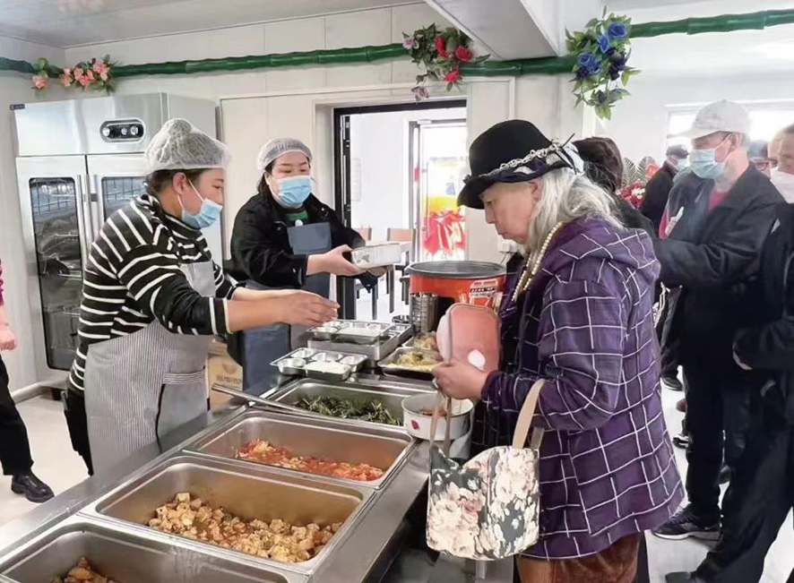 配文1：社區(qū)居民在食堂打飯。