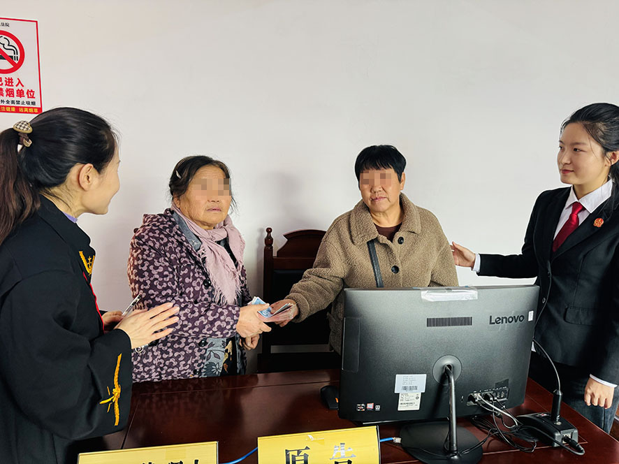 在楊光（左一）和張秋媛（右一）見證下，雙方履行調解協(xié)議約定（需打碼）
