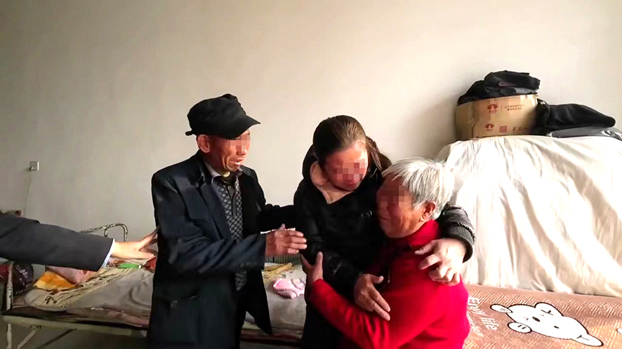 “肚兜女嬰”王麗（中）與父母團(tuán)圓。