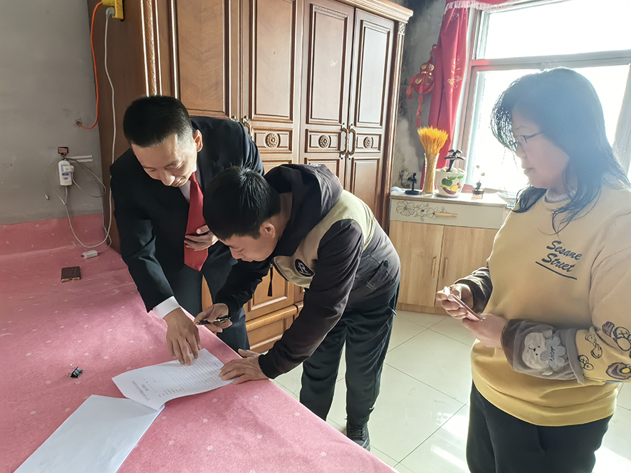 徐曉東（左一）指導(dǎo)孟某（中）在結(jié)案書(shū)上簽字