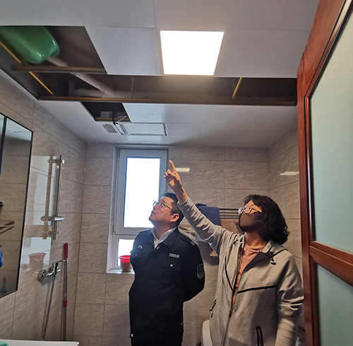 和平區(qū)法院執(zhí)行法官劉訓(xùn)兵（左）在申請執(zhí)行人家中查看漏水情況 劉鑫宇攝