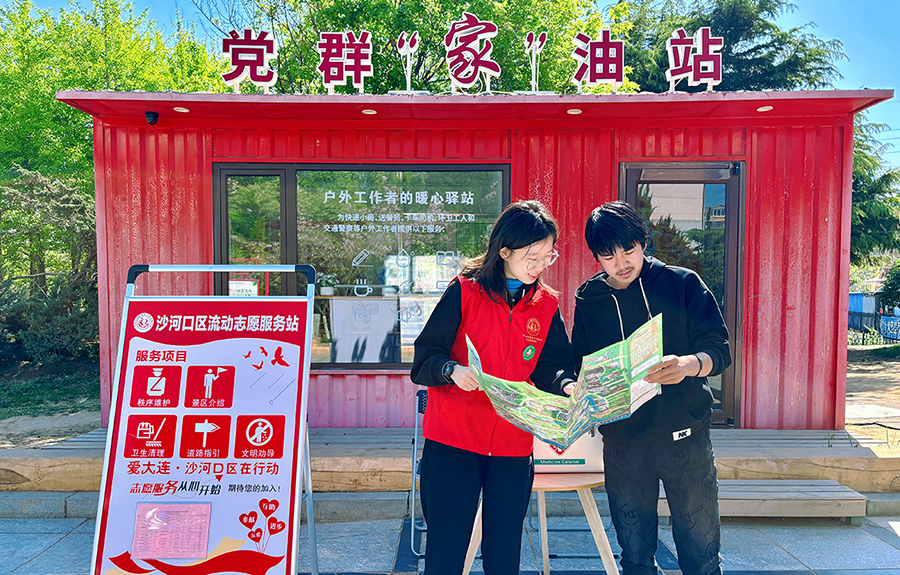 （頭題配圖）志愿者在大連沙河口區(qū)流動(dòng)志愿服務(wù)站服務(wù)游客