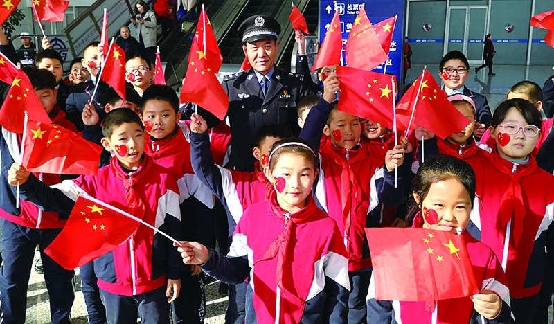 全國公安系統(tǒng)二級英雄模范沈陽市公安局蘇家屯分局民警李春和與轄區(qū)學(xué)校的孩子們?yōu)樽鎳鴳c生
