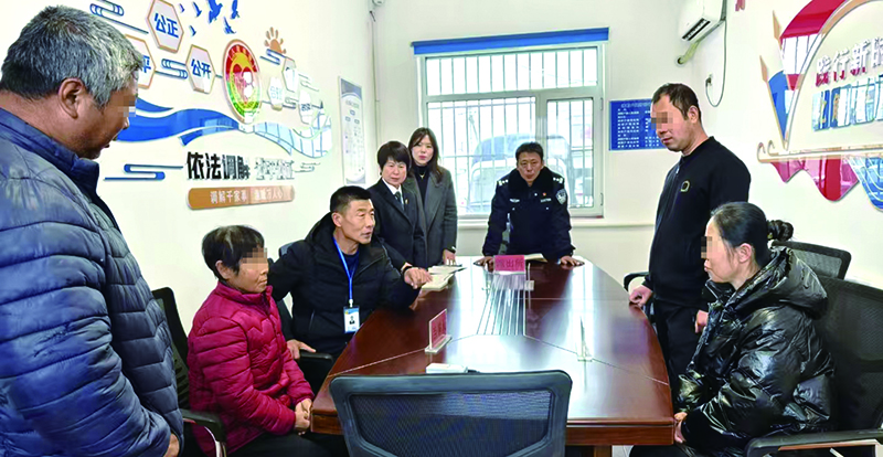 老孟（左三）協(xié)調(diào)公安、法院等多部門進行現(xiàn)場調(diào)解