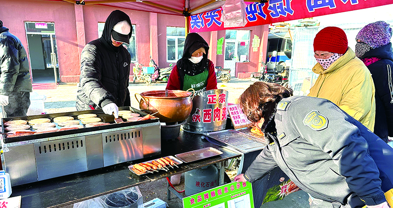 市場(chǎng)監(jiān)管工作人員查看食品攤販信息
