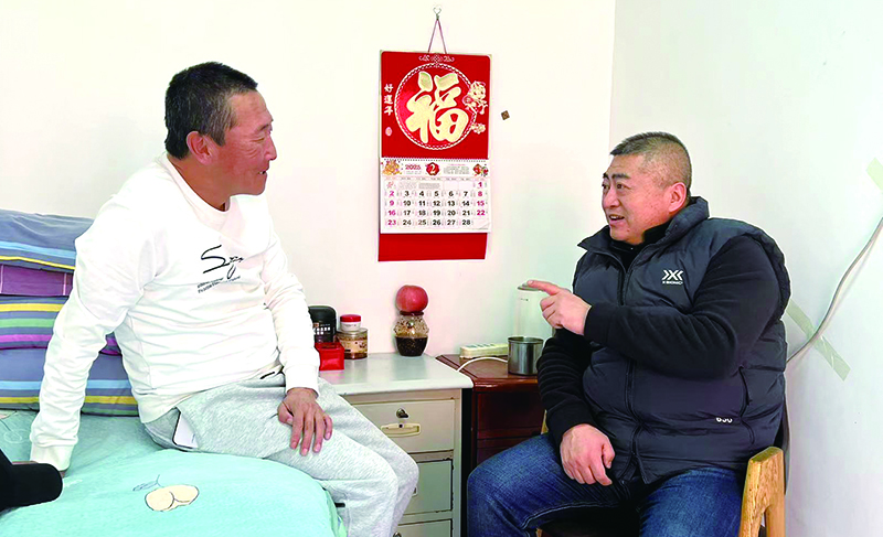 看守所所長(zhǎng)陳東東（右）與李海波談心