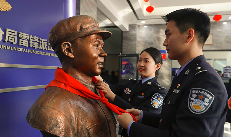 2024年3月5日，撫順市公安局望花分局雷鋒派出所民警白靜（右）和長沙市公安局雷鋒派出所民警韓政霖（左）共同為雷鋒塑像整理紅領(lǐng)巾。