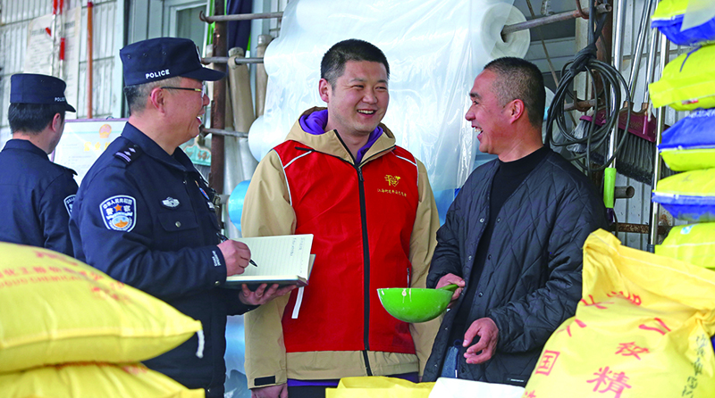 二題圖：在一家農(nóng)藥化肥經(jīng)銷店,民警向店主提示,農(nóng)忙時電信詐騙多,要注意防范電信詐騙,同時不要經(jīng)營偽劣農(nóng)藥化肥。