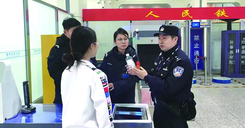 二題圖，童秋華（右）在向旅客講解安檢規(guī)定