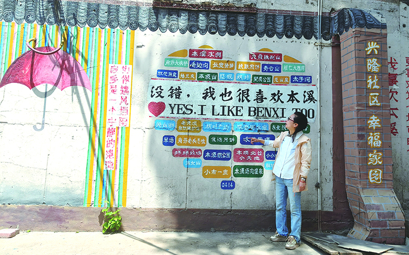 楊軼達(dá)向記者介紹社區(qū)的墻繪。