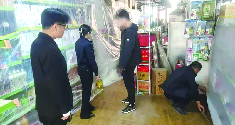 二圖，法院干警正在幫助一樓商戶粘貼防塵塑料布