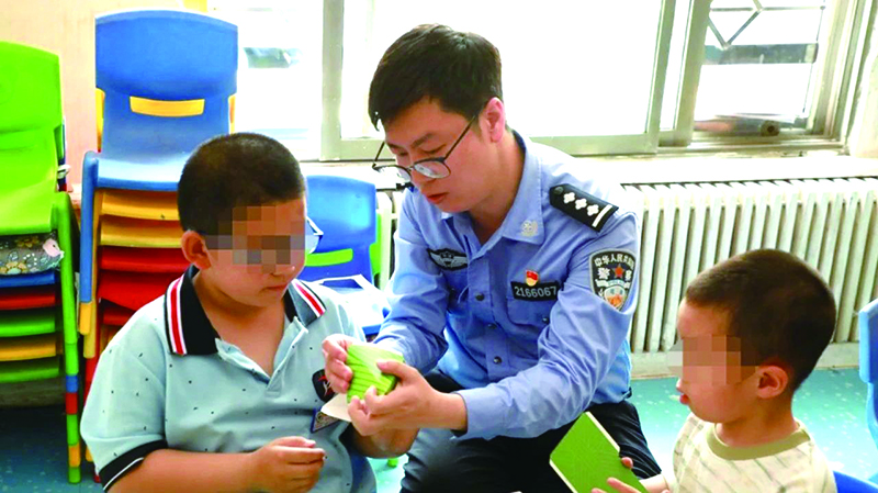 二題圖，民警在營(yíng)口市金石自閉癥兒童幼兒園指導(dǎo)孩子制作粽子折紙
