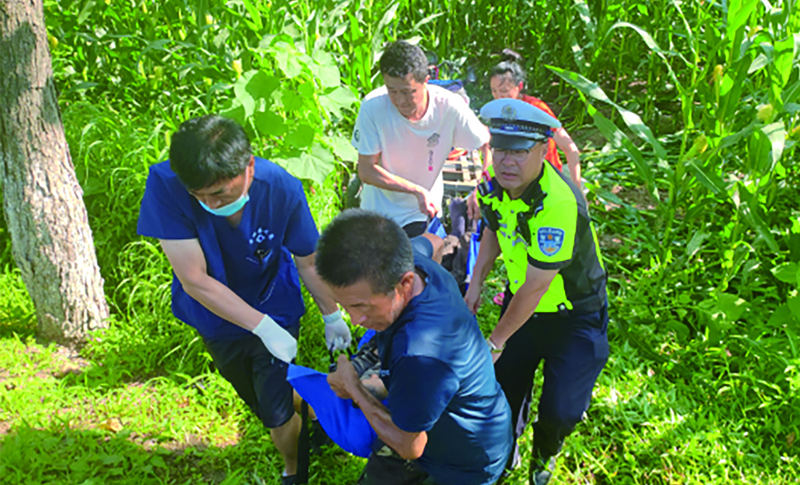 二題圖，民警配合醫(yī)護人員將受傷的駕駛人抬上救護車。
