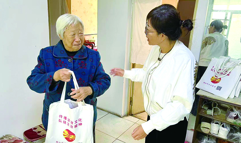 二題圖，姜云麗（右）為社區(qū)老人送去反詐宣傳冊