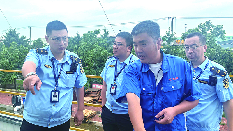 執(zhí)法人員正檢查某企業(yè)污染防治設(shè)施運行情況