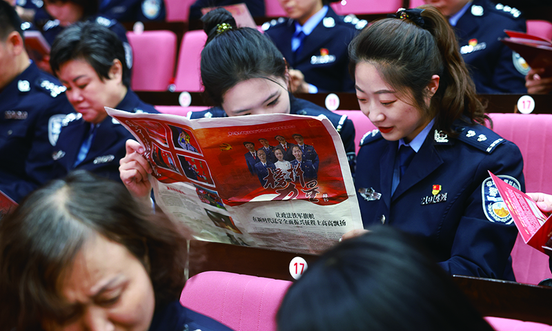 政法干警仔細(xì)翻閱《榜樣力量》特刊