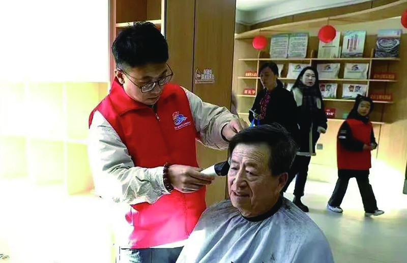 3美發(fā)師志愿者小王正在為獨(dú)居老人張大爺理發(fā)。