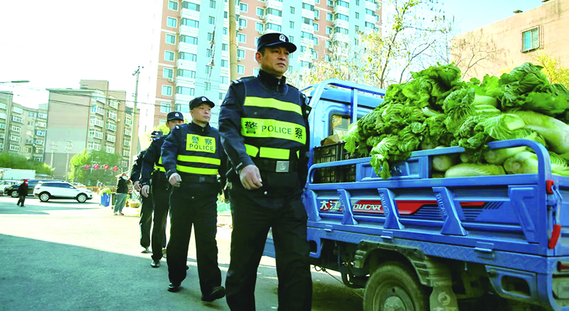 二題圖，民警在秋菜售賣(mài)攤位集中區(qū)域開(kāi)展巡邏