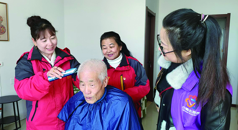 二題圖，專(zhuān)業(yè)社工帶領(lǐng)志愿者們上門(mén)為居民義剪