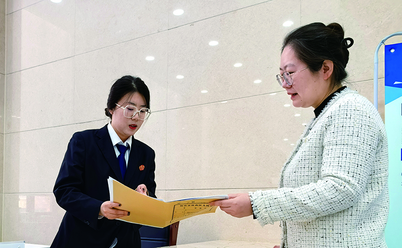 訴服中心的涉企案件綠色通道窗口，法官助理張嘉鑫正耐心指導(dǎo)當(dāng)事人填寫訴答文書